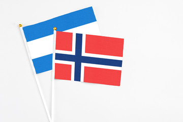 Norway and Nicaragua stick flags on white background. High quality fabric, miniature national flag. Peaceful global concept.White floor for copy space.