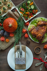 Thanksgiving dinner. Festive table with pumpkin, autumn leaves and seasonal autumn decor. Table setting in autumn style with a garland. Space for text.