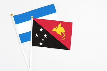 Papua New Guinea and Nicaragua stick flags on white background. High quality fabric, miniature national flag. Peaceful global concept.White floor for copy space.