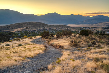 Hiking trail winding through Utah Valley near homes