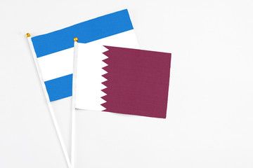 Qatar and Nicaragua stick flags on white background. High quality fabric, miniature national flag. Peaceful global concept.White floor for copy space.