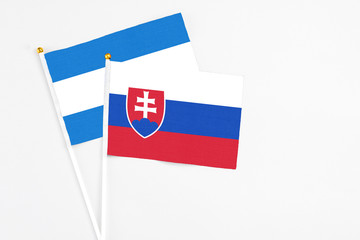 Slovakia and Nicaragua stick flags on white background. High quality fabric, miniature national flag. Peaceful global concept.White floor for copy space.