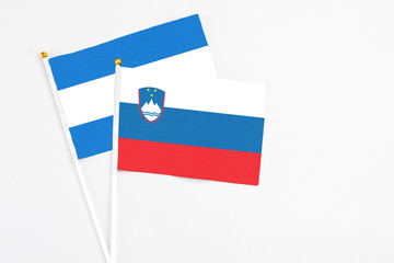 Slovenia and Nicaragua stick flags on white background. High quality fabric, miniature national flag. Peaceful global concept.White floor for copy space.