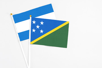 Solomon Islands and Nicaragua stick flags on white background. High quality fabric, miniature national flag. Peaceful global concept.White floor for copy space.