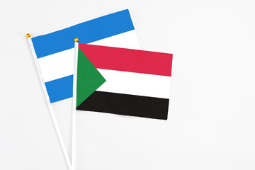 Sudan and Nicaragua stick flags on white background. High quality fabric, miniature national flag. Peaceful global concept.White floor for copy space.