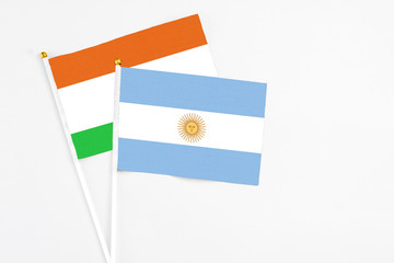 Argentina and Niger stick flags on white background. High quality fabric, miniature national flag. Peaceful global concept.White floor for copy space.