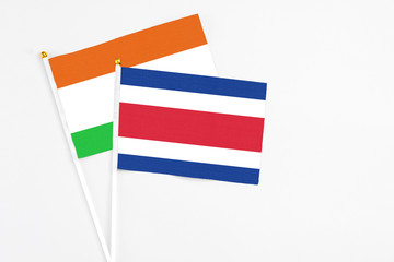 Costa Rica and Niger stick flags on white background. High quality fabric, miniature national flag. Peaceful global concept.White floor for copy space.