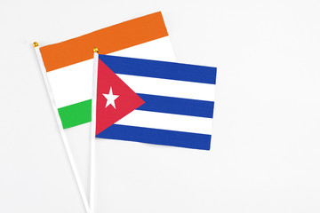 Cuba and Niger stick flags on white background. High quality fabric, miniature national flag. Peaceful global concept.White floor for copy space.