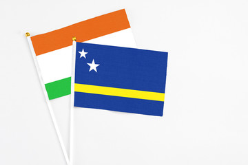 Curacao and Niger stick flags on white background. High quality fabric, miniature national flag. Peaceful global concept.White floor for copy space.
