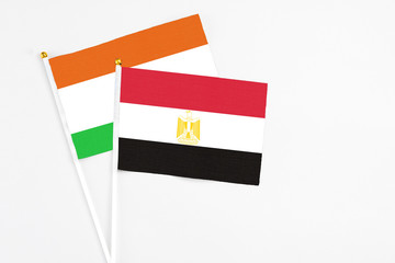 Egypt and Niger stick flags on white background. High quality fabric, miniature national flag. Peaceful global concept.White floor for copy space.