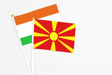 Macedonia and Niger stick flags on white background. High quality fabric, miniature national flag. Peaceful global concept.White floor for copy space.