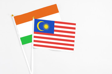 Malaysia and Niger stick flags on white background. High quality fabric, miniature national flag. Peaceful global concept.White floor for copy space.