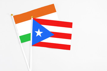 Puerto Rico and Niger stick flags on white background. High quality fabric, miniature national flag. Peaceful global concept.White floor for copy space.