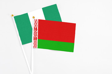 Belarus and Nigeria stick flags on white background. High quality fabric, miniature national flag. Peaceful global concept.White floor for copy space.
