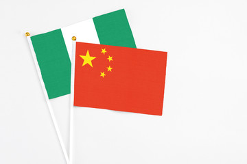 China and Nigeria stick flags on white background. High quality fabric, miniature national flag. Peaceful global concept.White floor for copy space.