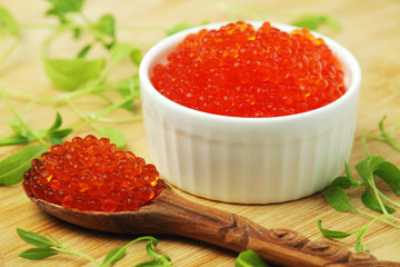 A small ceramic bowl with red caviar