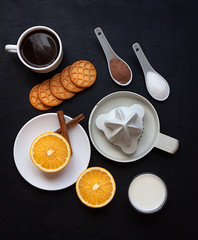 HEALTHY BREAKFAST WITH ORANGE, CINNAMON,MILK AND SQUEEZER ON BLACK BACKGROUND