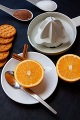 HEALTHY BREAKFAST WITH ORANGE, CINNAMON,MILK AND SQUEEZER ON BLACK BACKGROUND