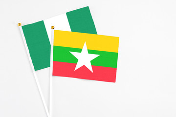 Myanmar and Nigeria stick flags on white background. High quality fabric, miniature national flag. Peaceful global concept.White floor for copy space.