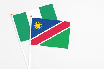 Namibia and Nigeria stick flags on white background. High quality fabric, miniature national flag. Peaceful global concept.White floor for copy space.