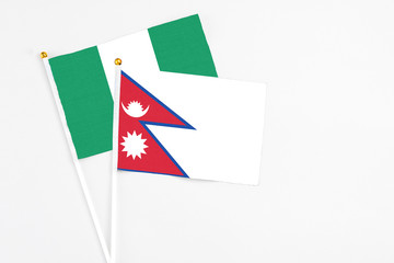 Nepal and Nigeria stick flags on white background. High quality fabric, miniature national flag. Peaceful global concept.White floor for copy space.