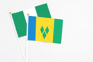 Saint Vincent And The Grenadines and Nigeria stick flags on white background. High quality fabric,...