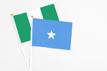 Somalia and Nigeria stick flags on white background. High quality fabric, miniature national flag. Peaceful global concept.White floor for copy space.