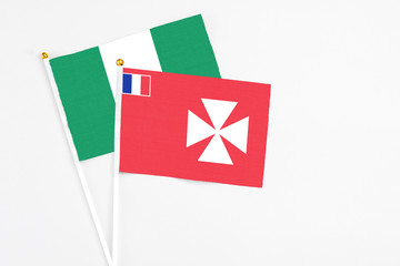 Wallis And Futuna and Nigeria stick flags on white background. High quality fabric, miniature national flag. Peaceful global concept.White floor for copy space.