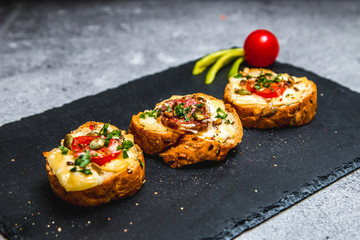 Baked crispy bruschettes with vegetables, cheese and meat