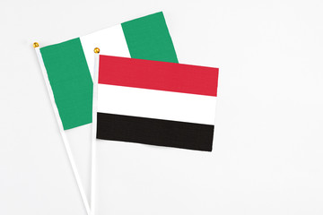 Yemen and Nigeria stick flags on white background. High quality fabric, miniature national flag. Peaceful global concept.White floor for copy space.