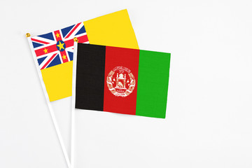 Afghanistan and Niue stick flags on white background. High quality fabric, miniature national flag....