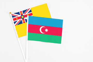 Azerbaijan and Niue stick flags on white background. High quality fabric, miniature national flag. Peaceful global concept.White floor for copy space.