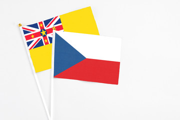 Czech Republic and Niue stick flags on white background. High quality fabric, miniature national flag. Peaceful global concept.White floor for copy space.