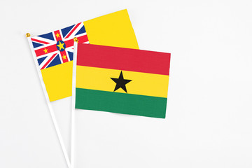 Ghana and Niue stick flags on white background. High quality fabric, miniature national flag. Peaceful global concept.White floor for copy space.