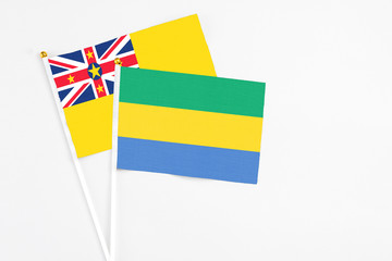Gabon and Niue stick flags on white background. High quality fabric, miniature national flag....