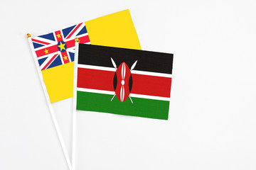 Kenya and Niue stick flags on white background. High quality fabric, miniature national flag. Peaceful global concept.White floor for copy space.