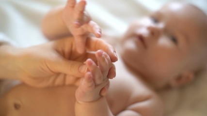 Cute baby holds mother's hand. Slow Motion 