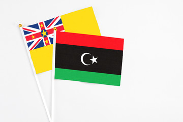 Libya and Niue stick flags on white background. High quality fabric, miniature national flag....