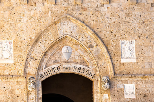 Siena, Italy - August 27, 2018: Sign in historic medieval old town village in Tuscany for Monte dei Paschi Sienna entrance on building