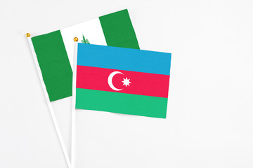 Azerbaijan and Norfolk Island stick flags on white background. High quality fabric, miniature national flag. Peaceful global concept.White floor for copy space.