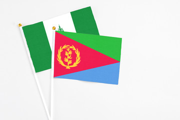 Eritrea and Norfolk Island stick flags on white background. High quality fabric, miniature national flag. Peaceful global concept.White floor for copy space.
