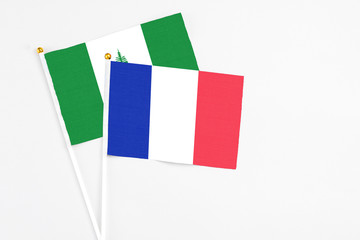 France and Norfolk Island stick flags on white background. High quality fabric, miniature national flag. Peaceful global concept.White floor for copy space.