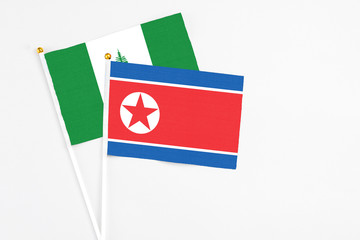 North Korea and Norfolk Island stick flags on white background. High quality fabric, miniature national flag. Peaceful global concept.White floor for copy space.