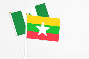 Myanmar and Norfolk Island stick flags on white background. High quality fabric, miniature national flag. Peaceful global concept.White floor for copy space.