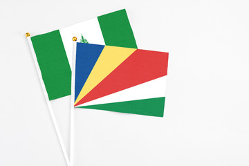 Seychelles and Norfolk Island stick flags on white background. High quality fabric, miniature national flag. Peaceful global concept.White floor for copy space.