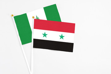 Syria and Norfolk Island stick flags on white background. High quality fabric, miniature national...