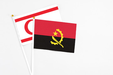 Angola and Northern Cyprus stick flags on white background. High quality fabric, miniature national flag. Peaceful global concept.White floor for copy space.