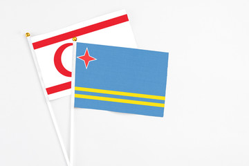 Aruba and Northern Cyprus stick flags on white background. High quality fabric, miniature national flag. Peaceful global concept.White floor for copy space.