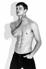 Fototapeta premium Black and White Muscle strong beautiful stripped male model in denim jeans on white isolated font background with shadow