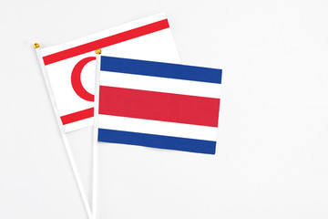 Costa Rica and Northern Cyprus stick flags on white background. High quality fabric, miniature national flag. Peaceful global concept.White floor for copy space.